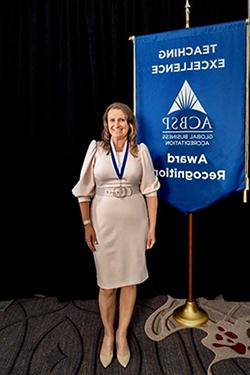 Justyna Koc standing in front of ACBSP Award Banner